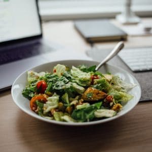 salad on white ceramic bowl on top of table near laptop